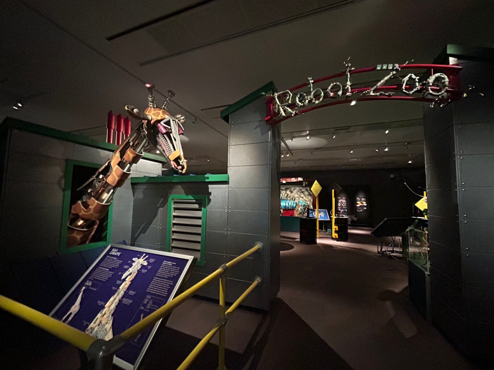 The entrance to the Horniman Museum's exhibition Robot Zoo, with a giraffe animatronic and information board.