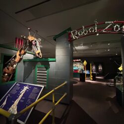 The entrance to the Horniman Museum's exhibition Robot Zoo, with a giraffe animatronic and information board.