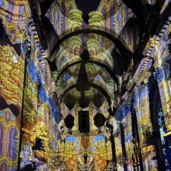 Yellow and blue light projections onto the walls and ceiling of St. Paul's Cathedral.