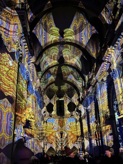 Yellow and blue light projections onto the walls and ceiling of St. Paul's Cathedral.