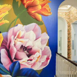 Sophie Mess's mural at the stairway of the Saatchi Gallery, where she has painted bold yellow, pink and red flowers against a royal blue backdrop.