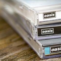 A photograph of a collection of Oasis CDs.