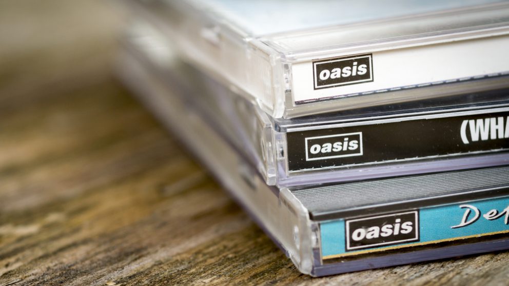 A photograph of a collection of Oasis CDs.